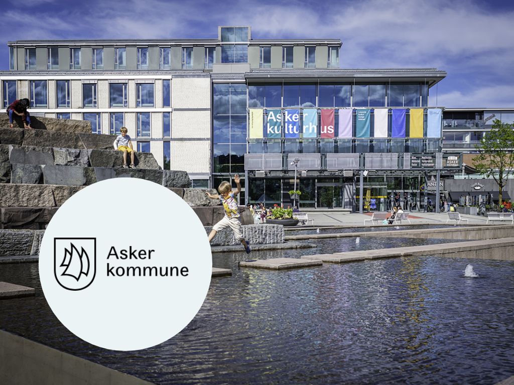 En dame holder frem en mobiltelefon med nettsiden til Asker kommune til kamera.