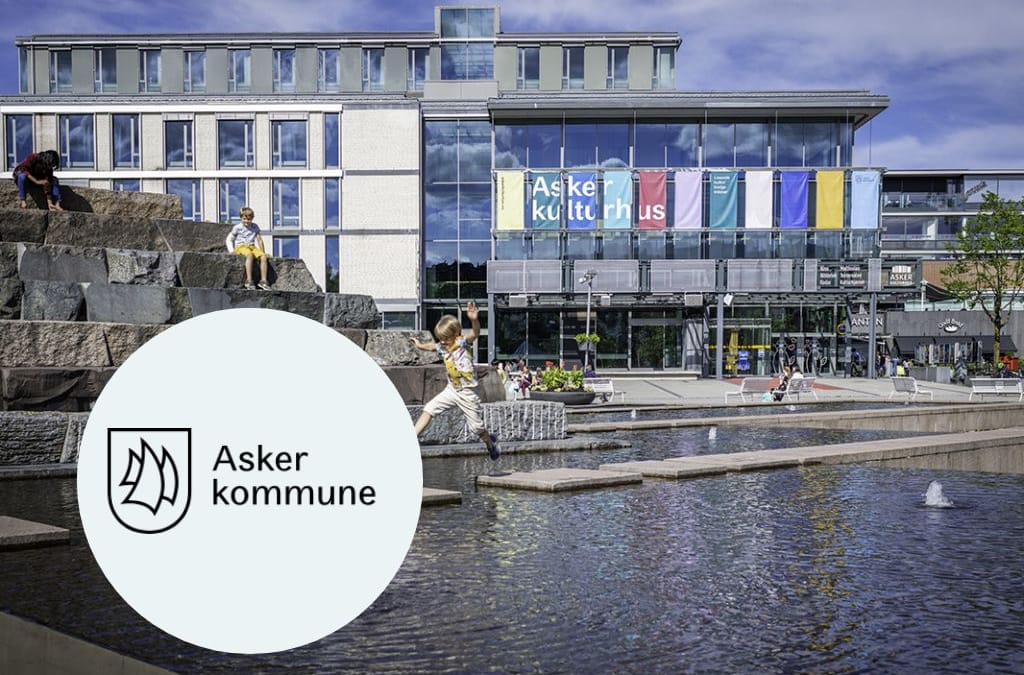 En dame holder frem en mobiltelefon med nettsiden til Asker kommune til kamera.