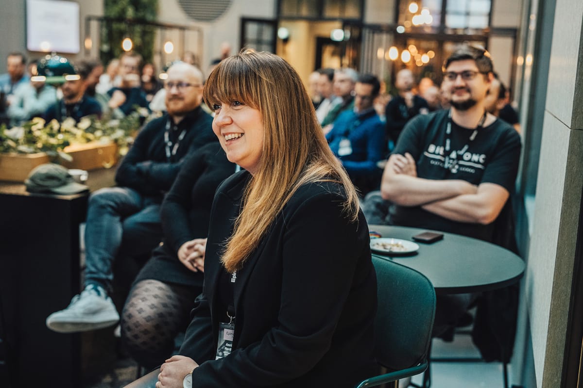 Ansatte i Epinova sitter og ser på en presentasjon. En kvinne sitter i front.