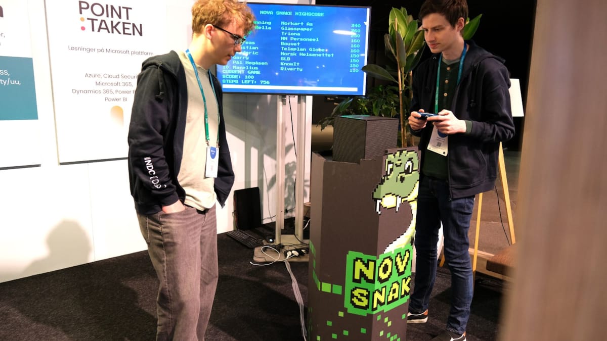To utviklere som spiller Snake på stand